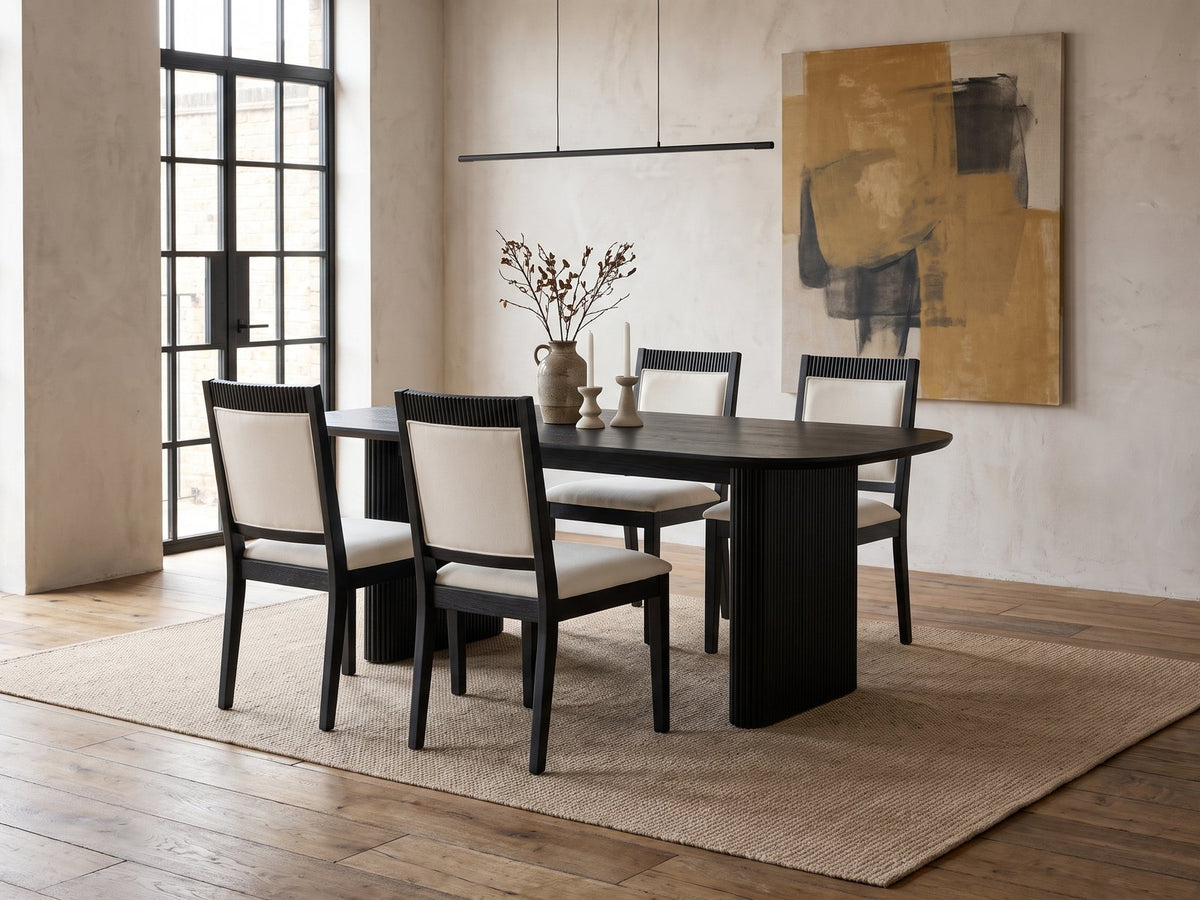Lungro 82-Inch Reeded Black Oak Extension Dining Set with 4 Chairs in an industrial loft dining area