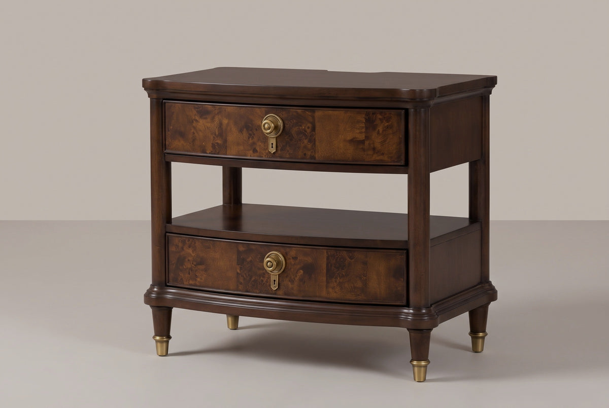 The Luras two-drawer nightstand in dark cherry with golden burl drawer fronts, brass knobs, an open tier and shelf and brass-capped legs, three-quarter view on a warm studio backdrop