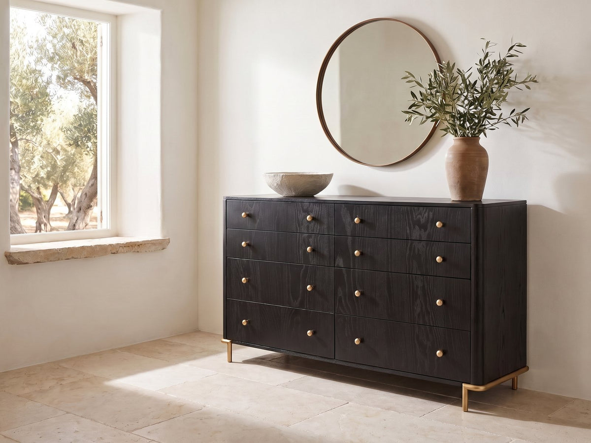 Malcesine 63-Inch Wire-Brushed Black 8-Drawer Dresser under a round bronze mirror in a villa bedroom