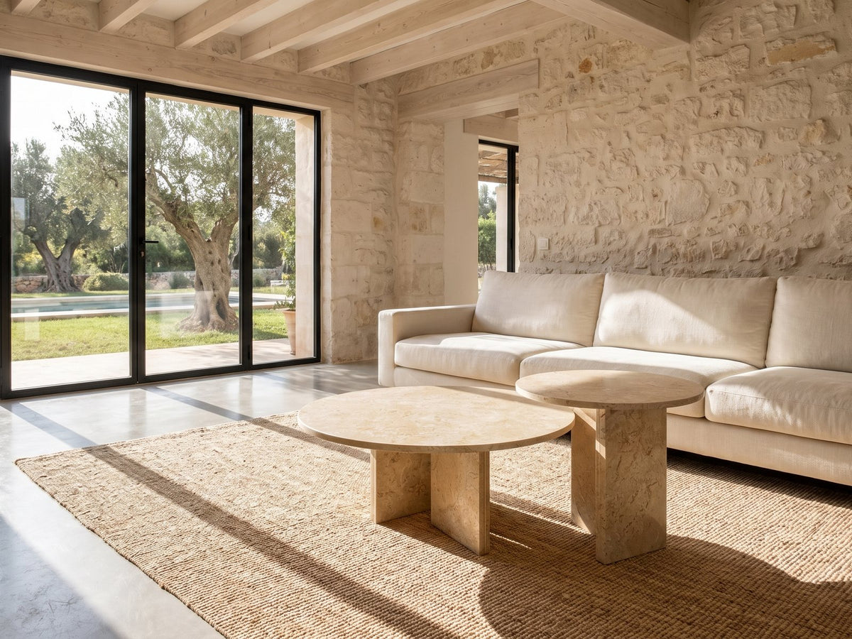 Mantova Gold Beige Marble Nesting Coffee Tables, Set of 2 on a jute rug in front of a linen sofa in a poolside villa