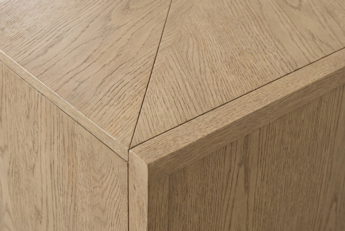 Close-up of the light caramel oak veneer on the Maratea sideboard: open grain, a mitred edge and the book-matched seam on the top