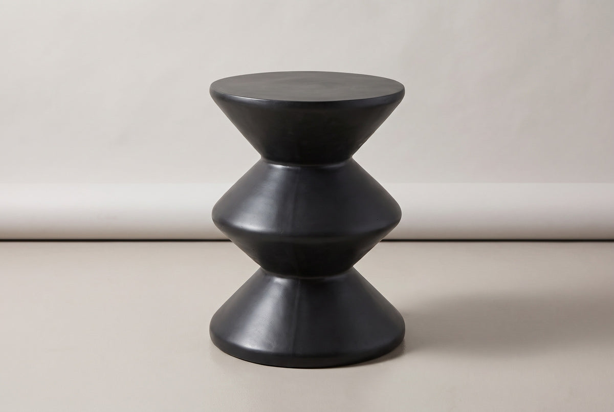 The Marineo black concrete zigzag side table, three-quarter view on a light studio backdrop