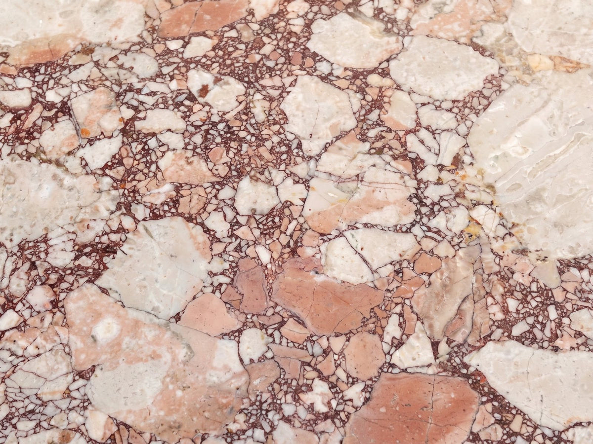 Close-up of the Marzamemi Rosa Marble Nesting Coffee Tables, Set of 2: the breccia veining of the polished rosa marble