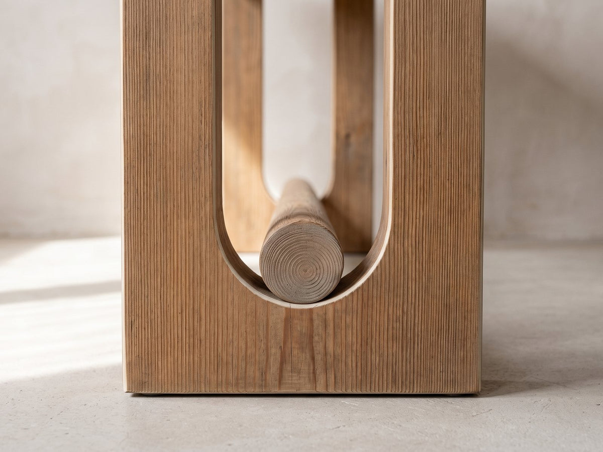 Close-up of the Matelica Reclaimed Pine Trestle Console Table: the U-shaped slot of an end panel with the round stretcher resting in its curved bottom