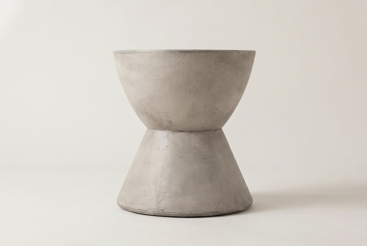 The Mazzaro side table seen straight from the side: the curved upper bowl, the narrow waist and the straight cone base