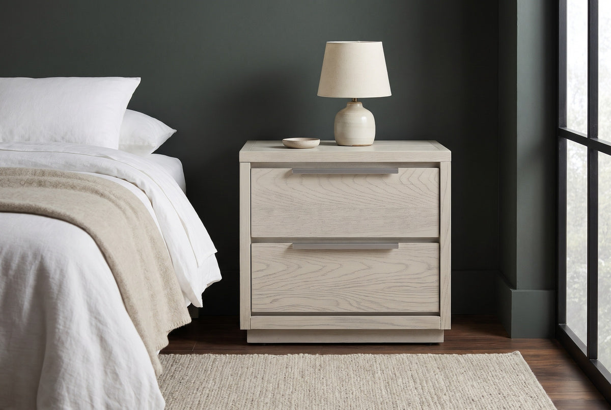 Melfi gray oak nightstand with a ceramic lamp against a deep green wall in a Portland bedroom with a dark wood floor and a wool rug