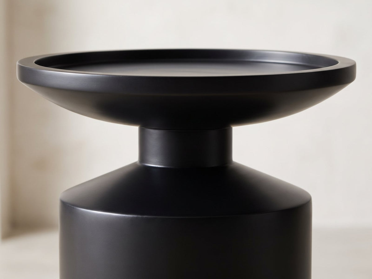 Close-up of the Mesoraca Black Mango Pedestal Side Table: the raised rim of the tray top over the neck and the sloped shoulder