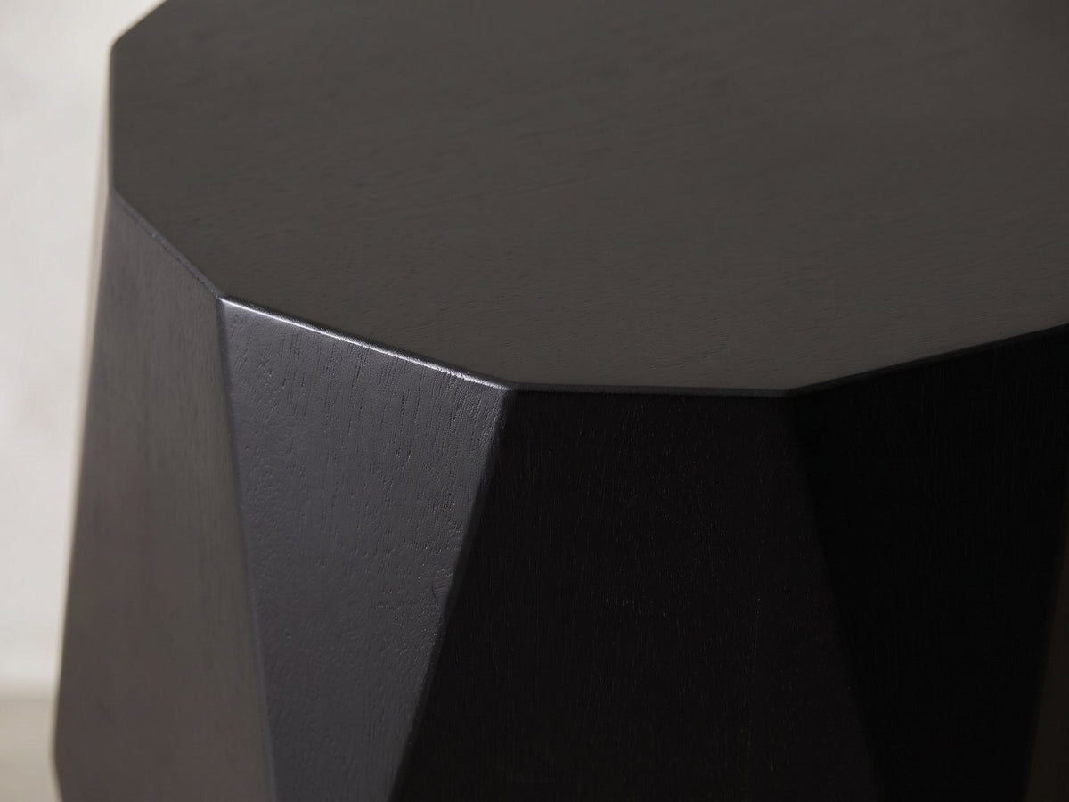 Close-up of the Miglionico Black Mango Wood Faceted Drum Side Table: the crisp facet edges under the 12-sided top