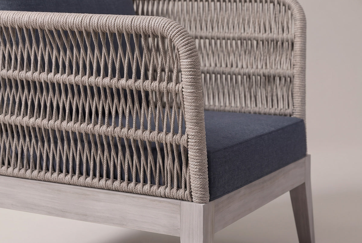 Close-up of the woven grey rope on a Mistretta arm: open zigzag rows, horizontal ribs and the rounded rope edge, above the greywash acacia base