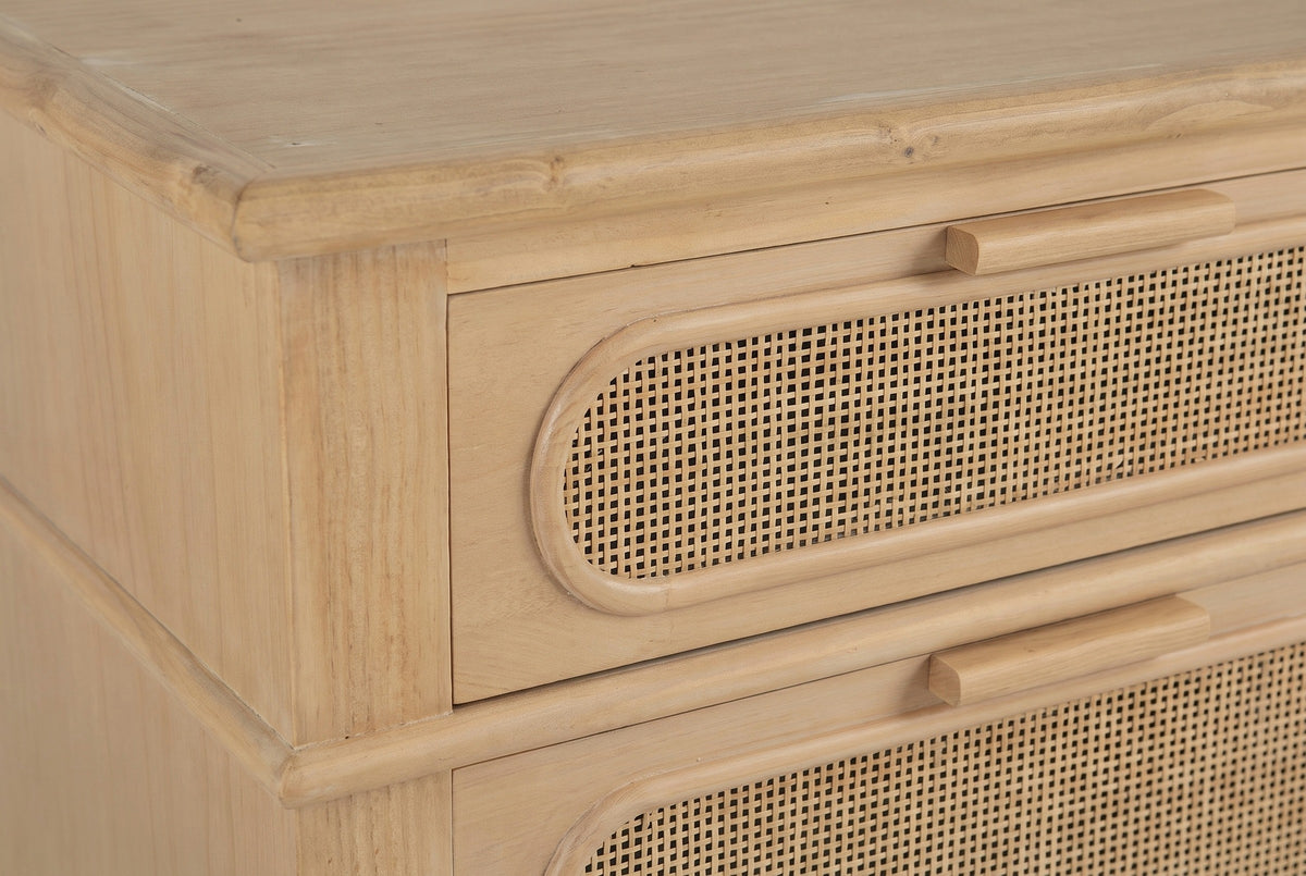 The top of the Mogoro nightstand: the rounded top edge, the upper drawer with its pill-shaped cane panel and wood bar pull, and the moulding band above the lower drawer