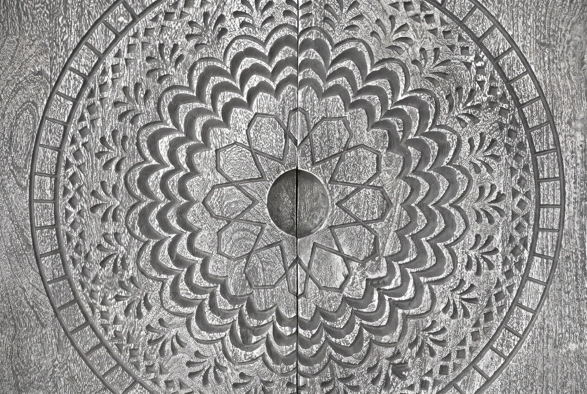 The centre of the Molfetta medallion: the round carved hollow between the two doors, the eight-point star, scalloped petals, leaf sprays and the outer ring of small blocks