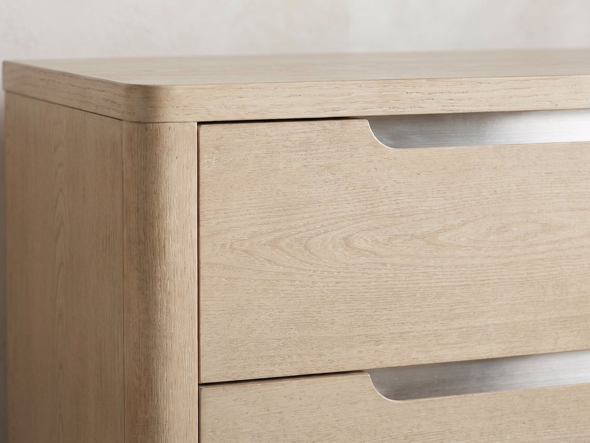 Close-up of the Monselice 38-Inch Light Elm 5-Drawer Chest: the recessed brushed-nickel finger-pull slot at the top of a drawer