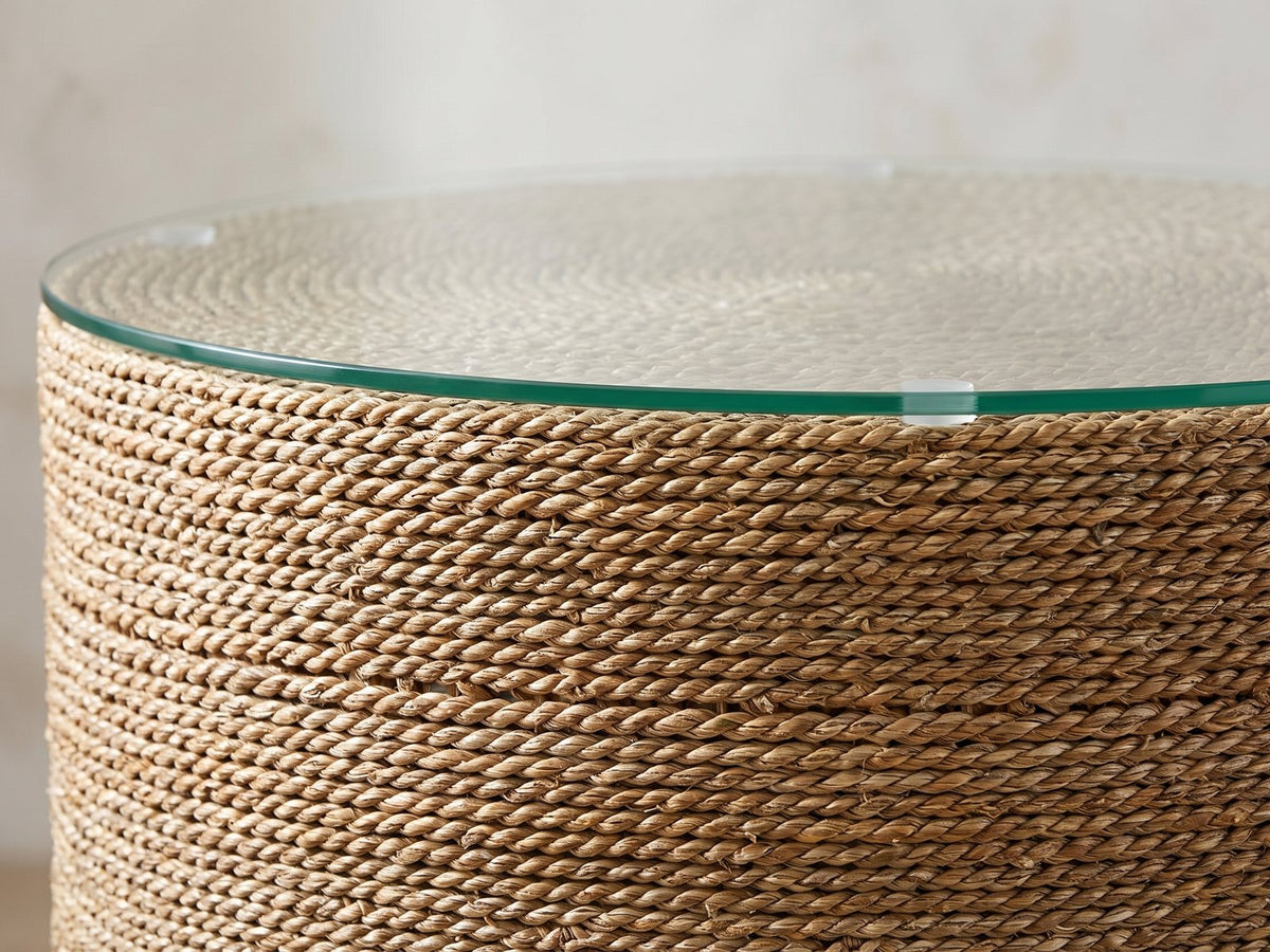 Close-up of the Montescaglioso Woven Seagrass Drum Side Table: the glass top resting on the coiled seagrass rope