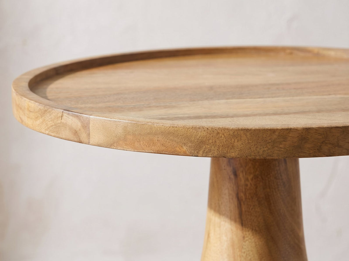 Close-up of the Montisi Natural Mango Pedestal Side Table: the raised rim of the round mango tray top