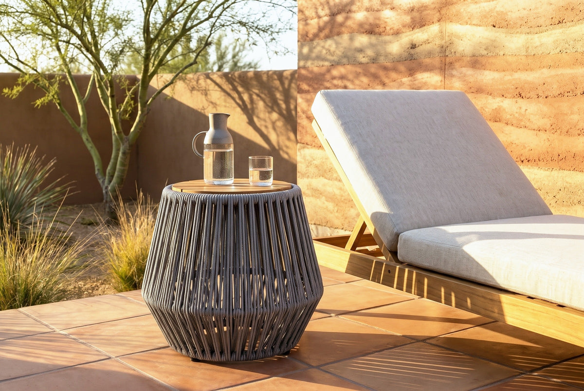 Naro rope side table with a water carafe and a glass beside a teak lounge chair on a saltillo tile patio in Tucson at golden hour, a rammed-earth wall behind (chair and decor not included)