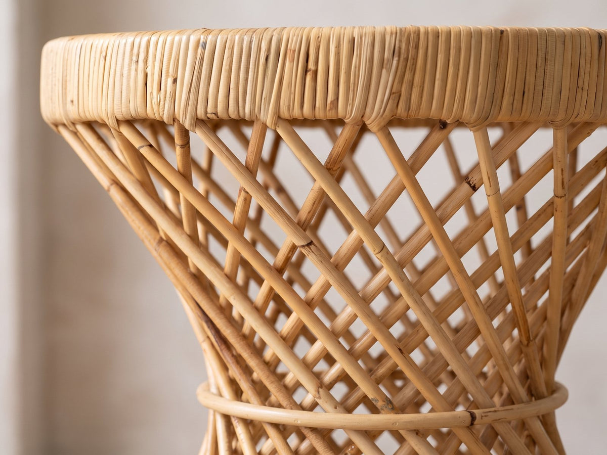 Close-up of the Neviano Natural Rattan Hourglass Side Table: the wrapped rattan rim over the crossing rattan poles and the waist hoop