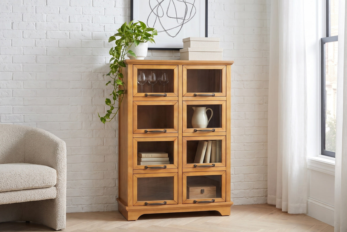 Noci pine display cabinet with a pothos plant on top against a white-painted brick wall in a Brooklyn brownstone living room with a herringbone floor
