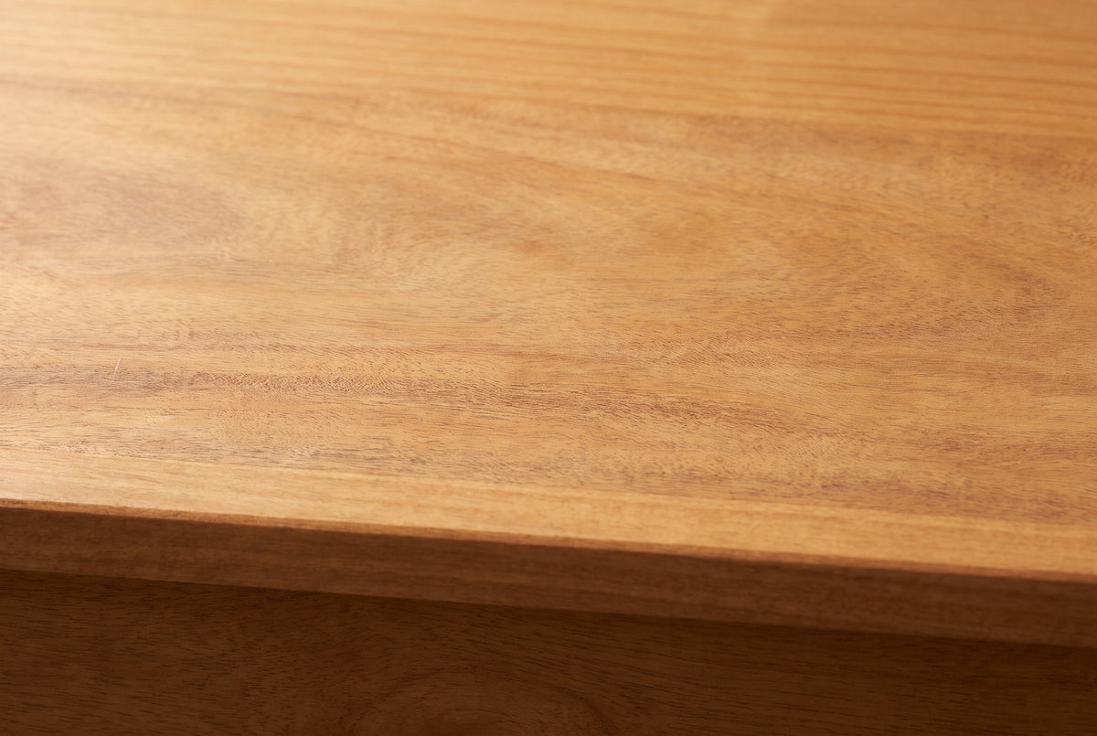 Close-up of the honey pine on the Noci cabinet: soft grain with warm amber tones running to a square edge