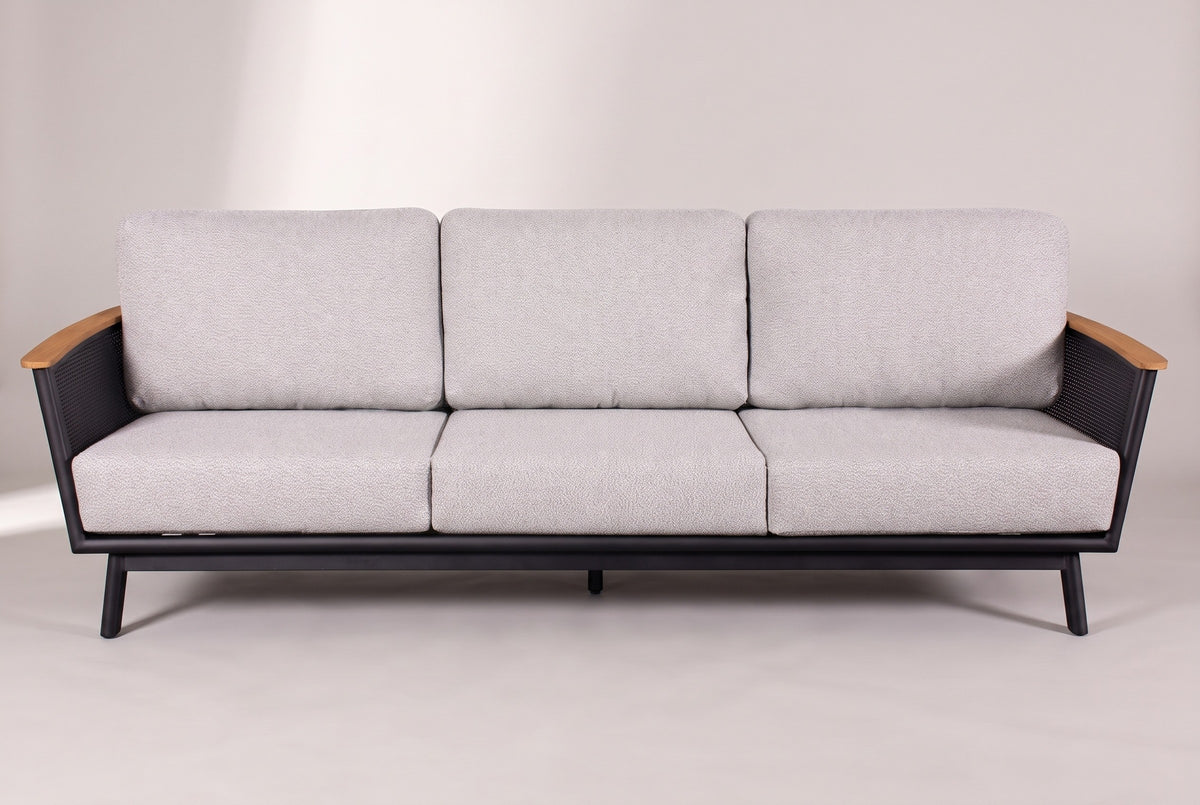 The Ognina sofa seen from the front: two flared mesh arms with teak tops, three seat cushions and three back cushions