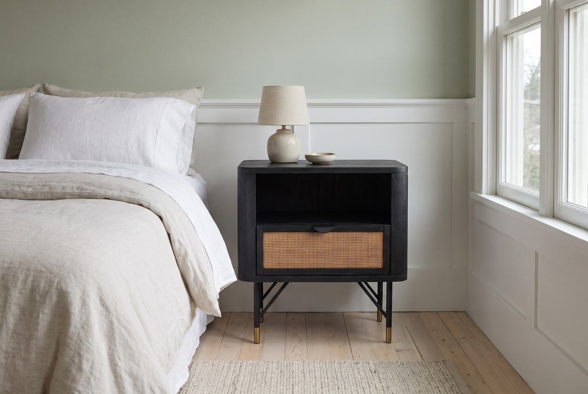Olbia black acacia and rattan nightstand against a pale sage wall above white wainscot panelling in a Portland craftsman bedroom with pale ash floorboards