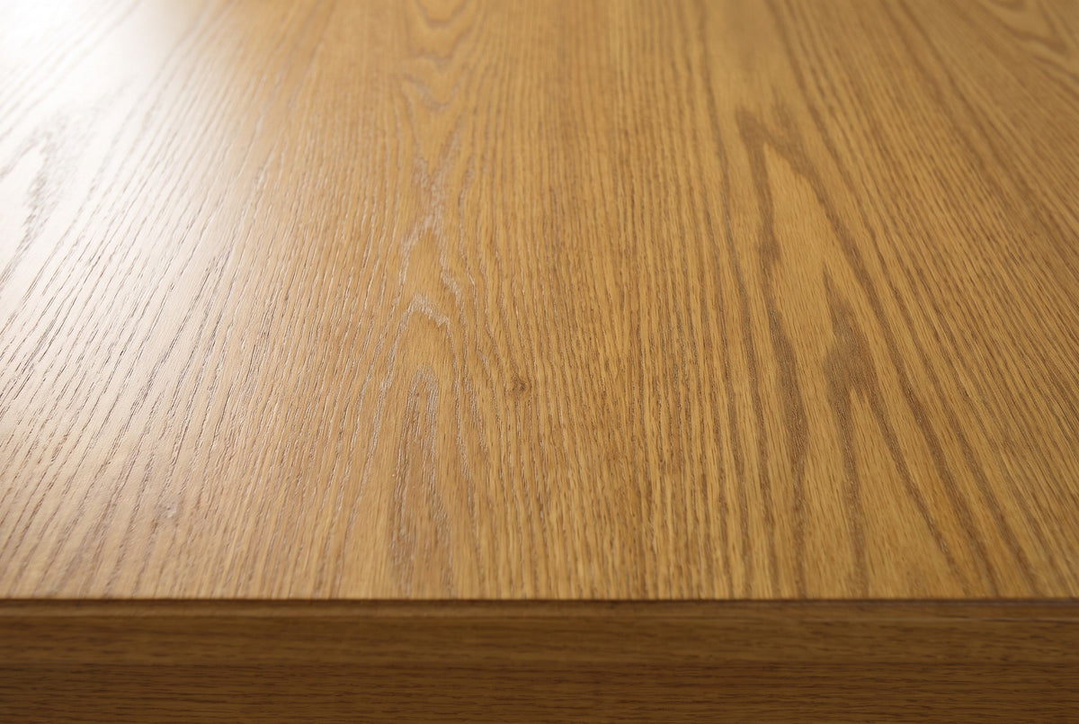Close-up of the Orgosolo nightstand top: Camel Oak wood veneer with open oak grain and a soft sheen, with the square edge of the top below