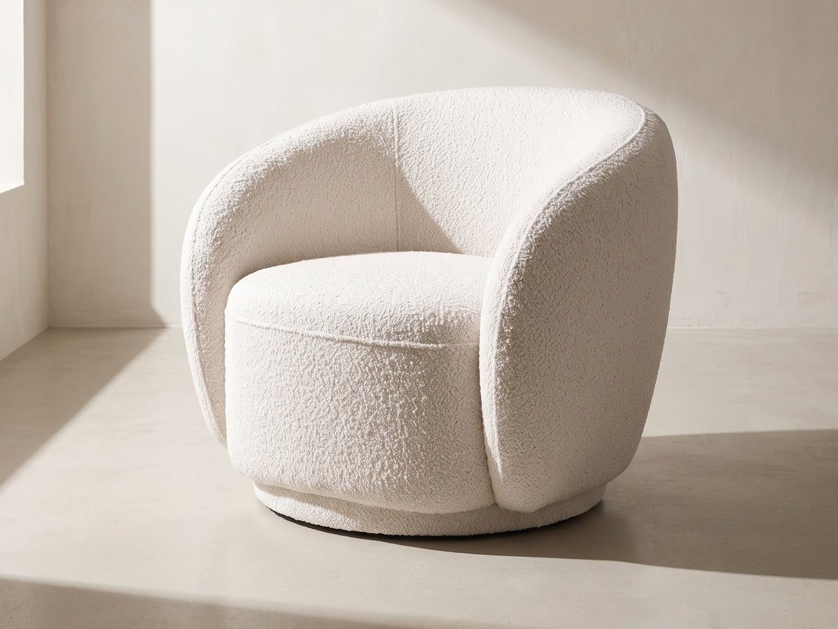 Ostuni Boucle Swivel Chair in off white against a plaster wall in morning light