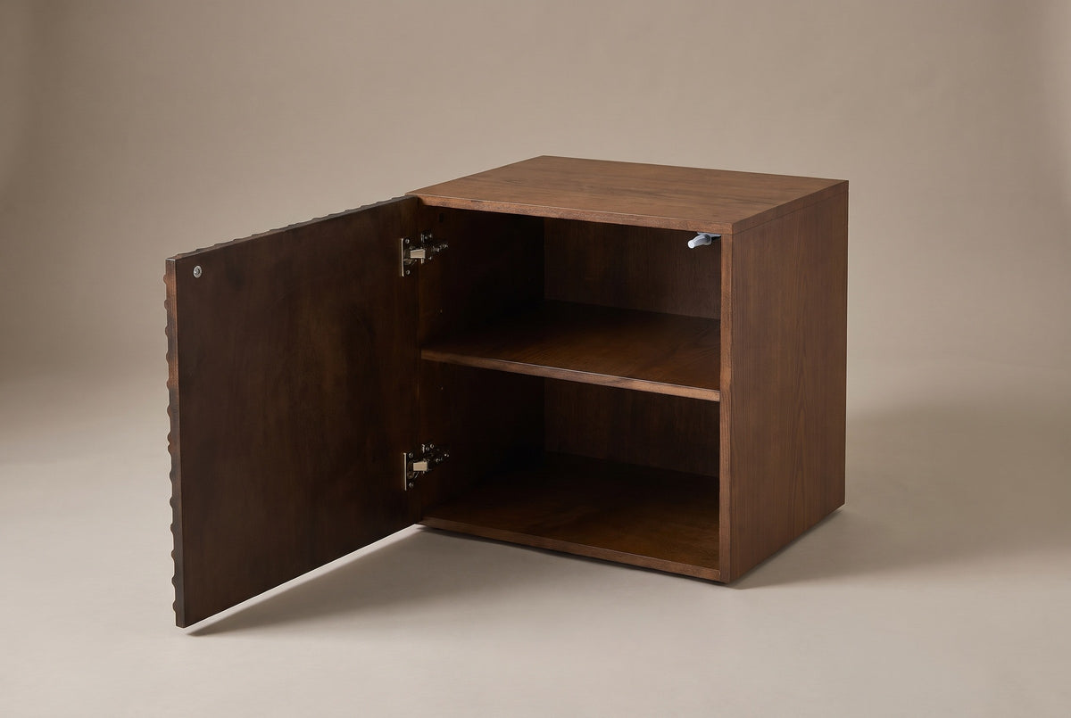 The Ozieri nightstand with its door open, showing one shelf inside