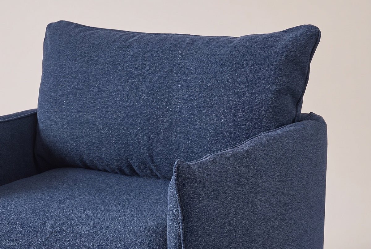 The Palazzolo chair up close: the big loose back pillow with its flange edge and the slim arm with its top seam