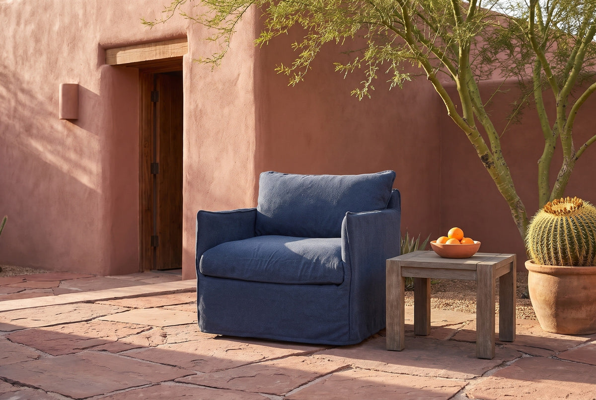 Palazzolo navy club chair in a Tucson adobe courtyard on red flagstone, a palo verde tree and a barrel cactus beside it (side table not included)