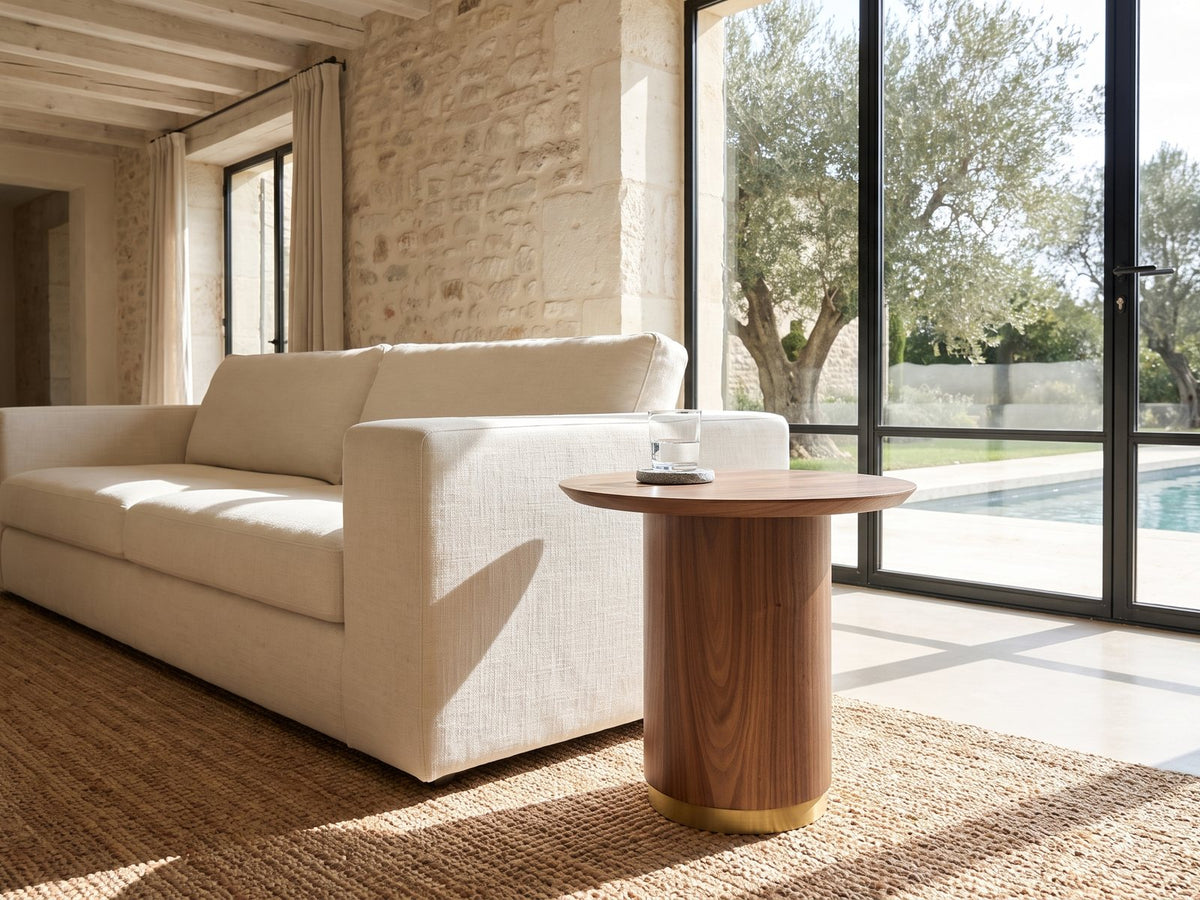 Pietrapertosa Walnut Pedestal Side Table beside a linen sofa in a poolside villa