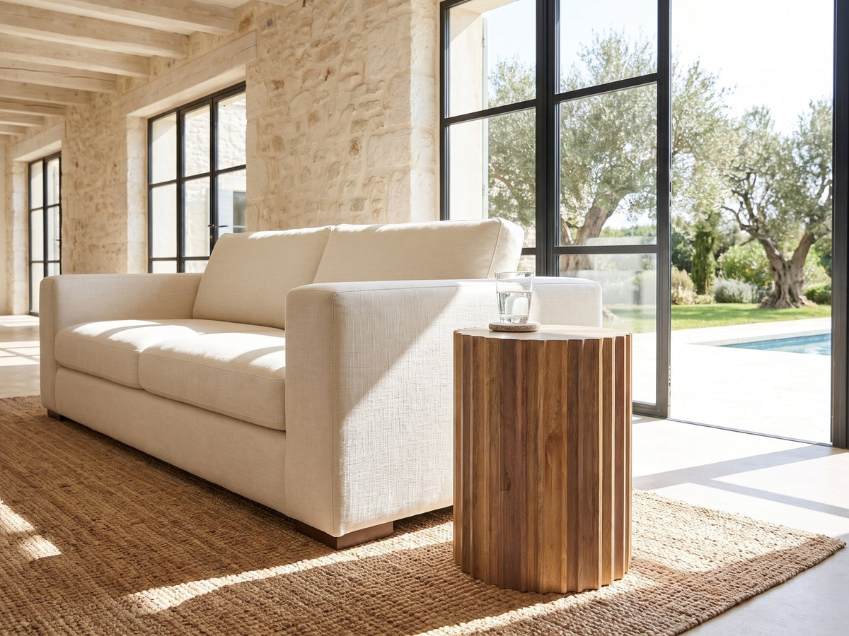 Pisticci Solid Mango Fluted Drum Side Table beside a linen sofa in a poolside villa