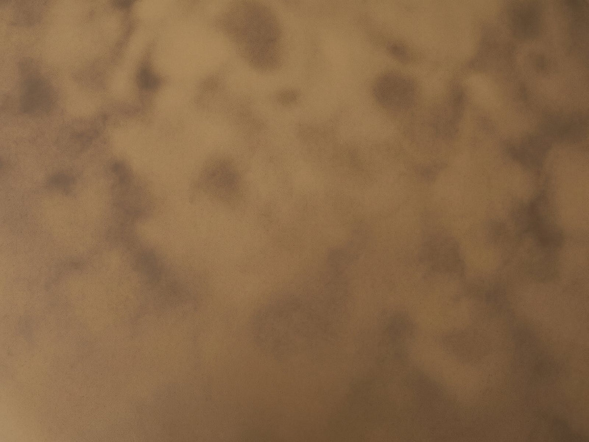 Close-up of the Pitigliano Brass-Finish Fluted Drum Coffee Table: the mottled antique brass finish of the top