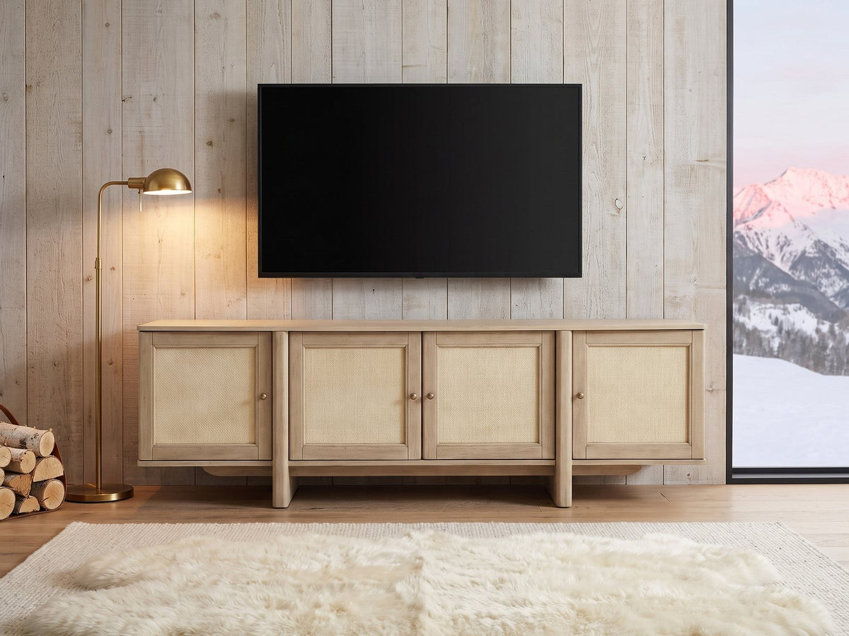 Polignano Oak and Cane Media Console under a wall-mounted screen in an alpine chalet at dusk