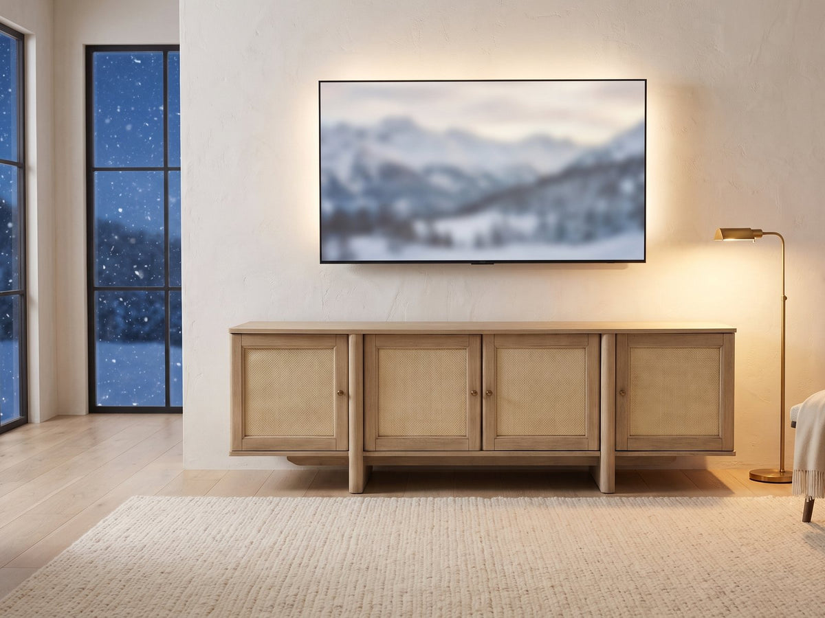 Polignano Oak and Cane Media Console under a screen showing a snowy landscape on a winter evening
