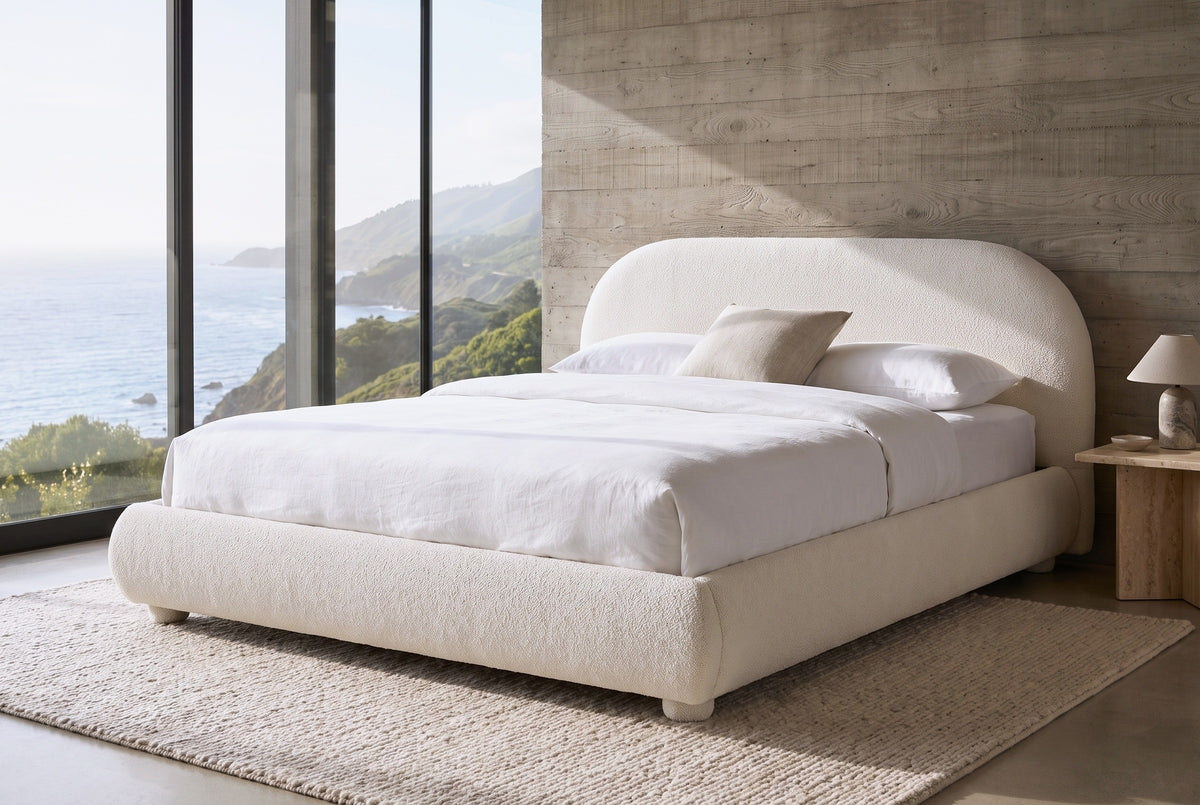 Pollutri bed against a board-formed concrete wall in a Big Sur house, the Pacific through a floor-to-ceiling window