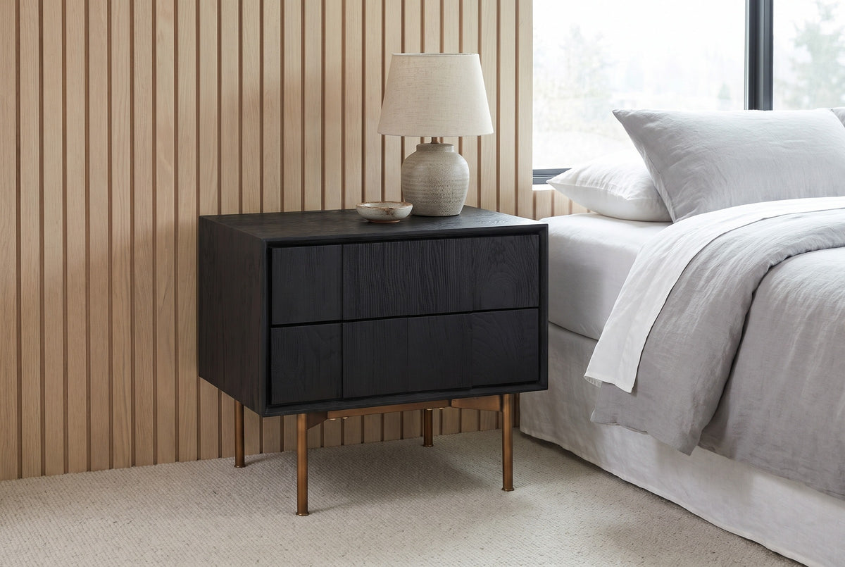 Posada black oak nightstand against pale white oak wall slats in a Seattle bedroom with a wool carpet