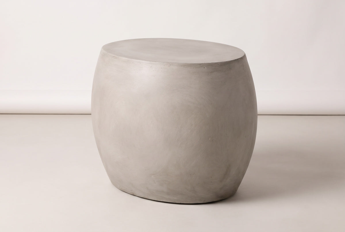 The Racalmuto light grey concrete oval barrel side table, three-quarter view on a light studio backdrop