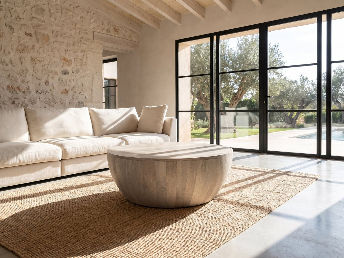 Rapallo Whitewashed Mango Bowl Coffee Table on a jute rug in front of a linen sofa in a poolside villa