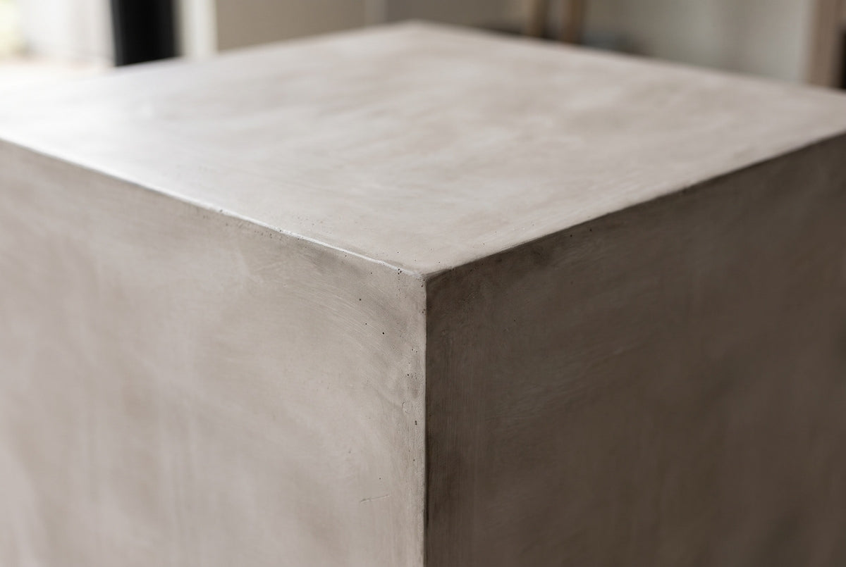 Close-up of the smooth light grey MGO lightweight concrete on a top corner of the Realmonte side table