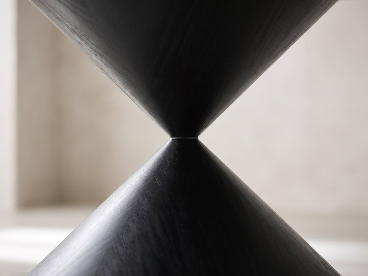 Close-up of the Rende 59-Inch Round Black Oak Hourglass Dining Set with 6 Chairs: the narrow waist where the two black oak cones of the hourglass pedestal meet