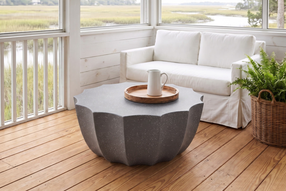 Ribera speckled gray coffee table on heart-pine boards on a screened Lowcountry porch near Charleston, a white slipcovered sofa, whitewashed shiplap and the marsh beyond (sofa, tray and pitcher not included)