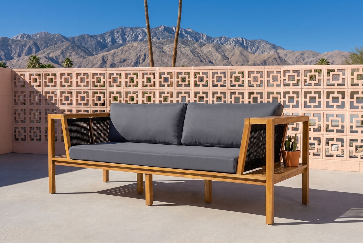 Riposto acacia daybed sofa on a Palm Springs patio in front of a peach breeze-block wall, palms and the San Jacinto mountains behind (plant not included)