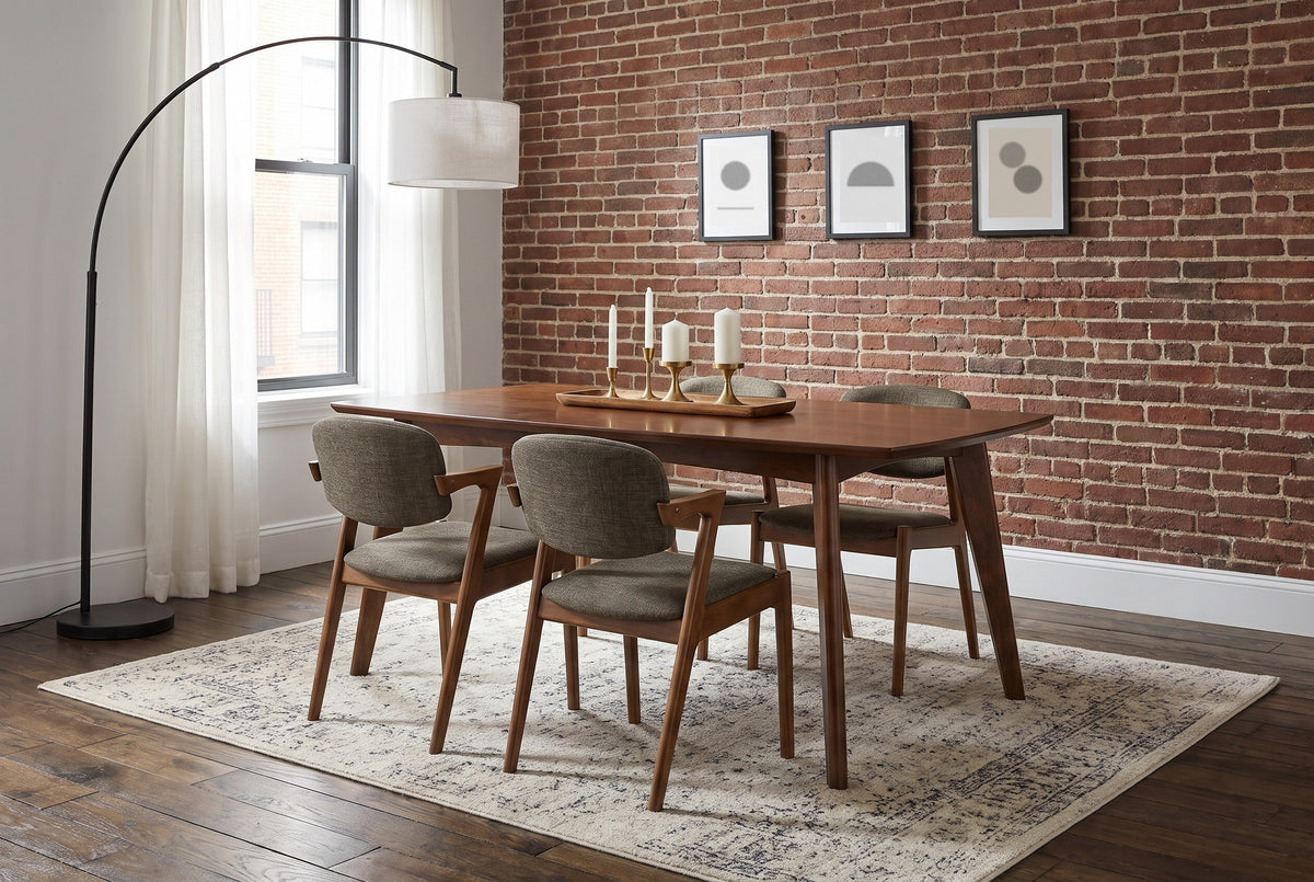 Rossano walnut-veneer dining table with four chairs against an exposed brick wall in a Boston dining room with dark oak floorboards