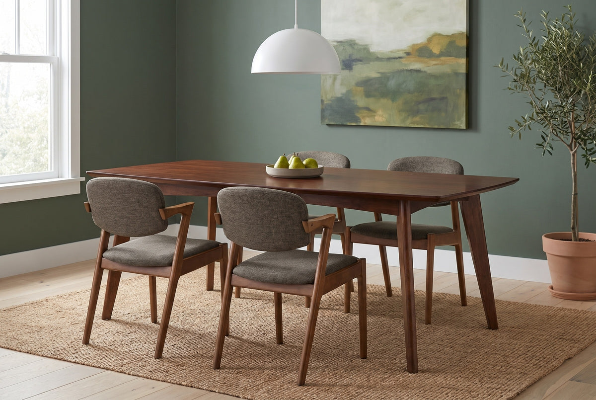 Rossano walnut-veneer dining table with four chairs against a deep sage-green plaster wall in a Portland dining room with a jute rug