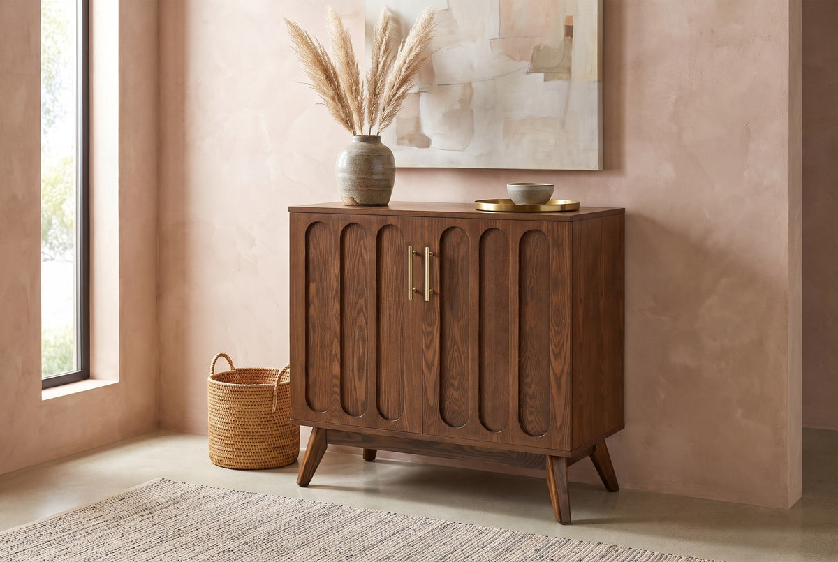 Ruvo walnut-finish cabinet with a pampas vase against a clay-pink limewash wall in an Austin entryway with a concrete floor