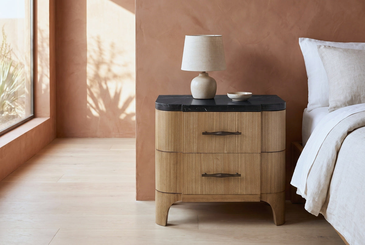 Samassi eucalyptus nightstand with a black stone top and a ceramic lamp beside a bed in a Scottsdale bedroom with a terracotta plaster wall