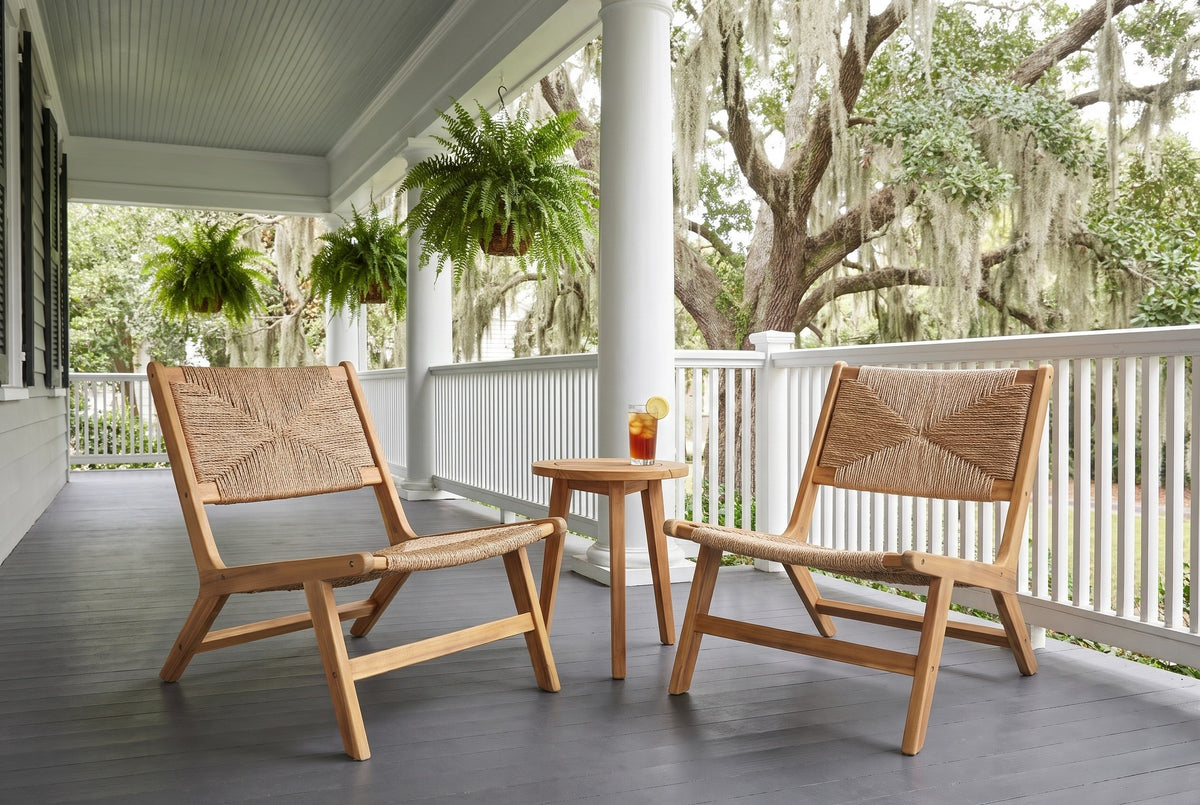 Two Scopello lounge chairs on a Savannah porch with a charcoal painted floor, grey-green beadboard ceiling, white columns and live oaks hung with Spanish moss (side table and drink not included)