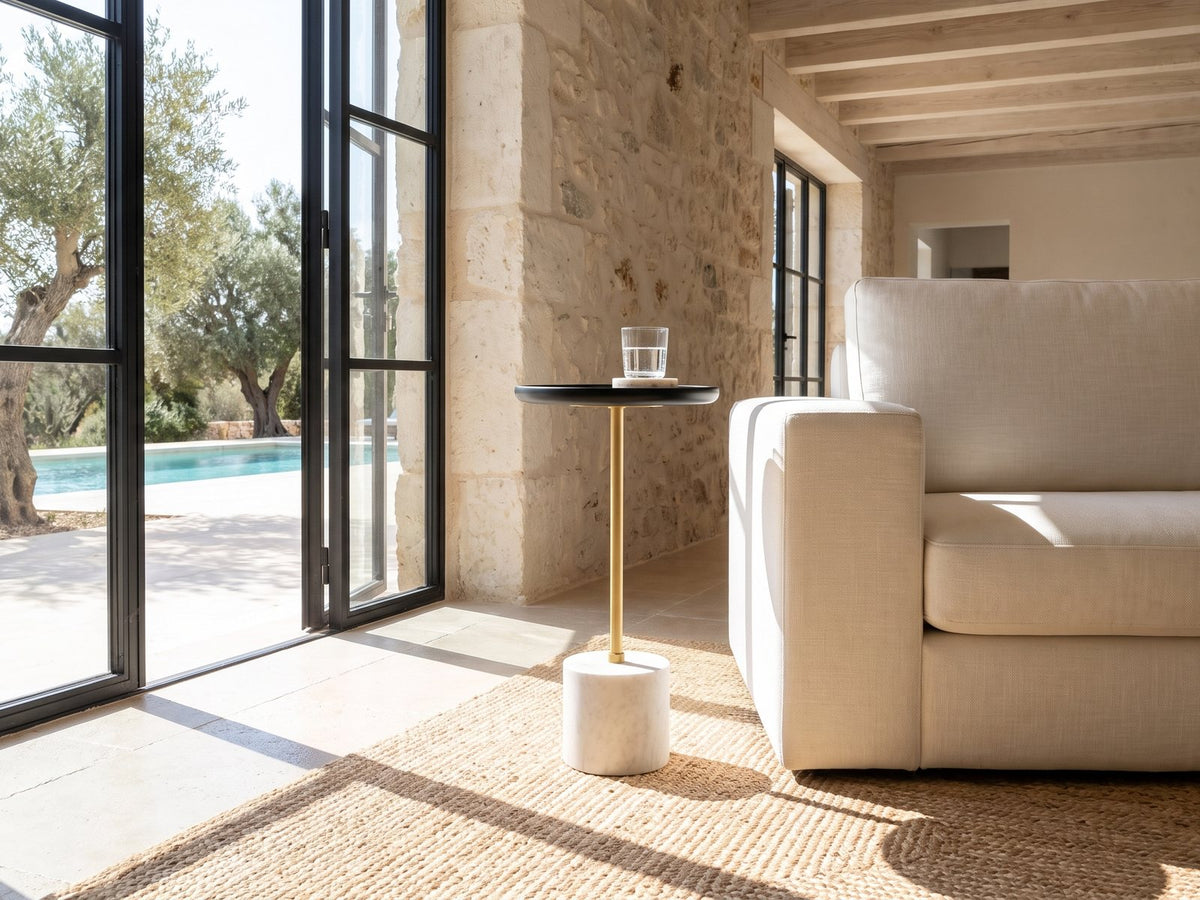 Seggiano Black Mango and Marble Drink Side Table beside a linen sofa in a poolside villa