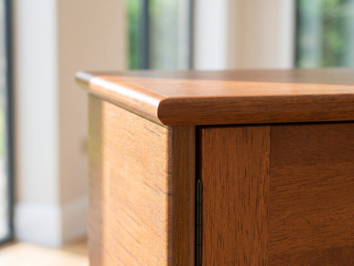 Close-up of the Senigallia Low Mid-Century Media Console: the top corner of the console: the solid wood top edge and the door with its black pull