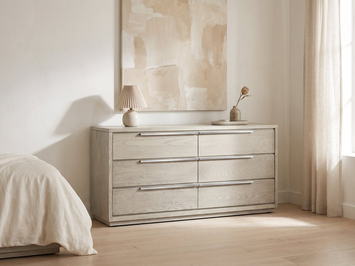 Sesto 63-Inch Gray Oak 6-Drawer Dresser against a plaster wall under an abstract canvas in a bright bedroom